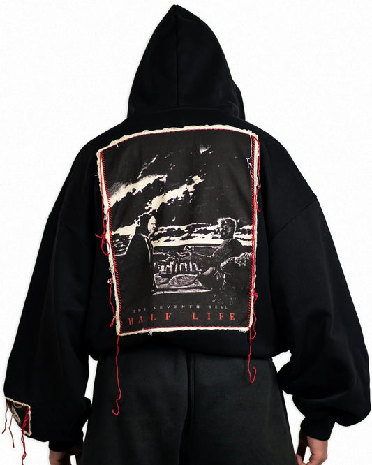 Black hoodie with graphic design on the back against a white background